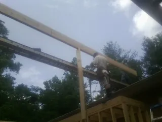 Carpenter setting a ridge beam over a new addition frame — Ice Dam Removal by Roofing Brothers in Atlantic Highlands