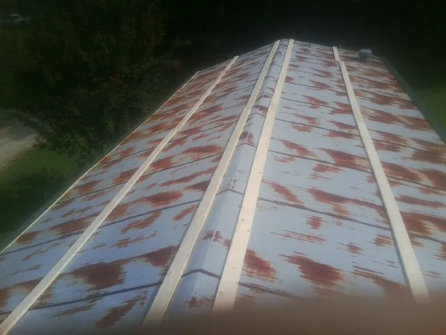 Rusted metal roof panels with new wood purlins before replacement — Storm Damage Roof Repair in Atlantic Highlands by Roofing Brothers