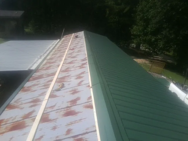 Old rusted panels beside newly installed green metal roofing — Wind Damage Roof Repair by Roofing Brothers in Atlantic Highlands