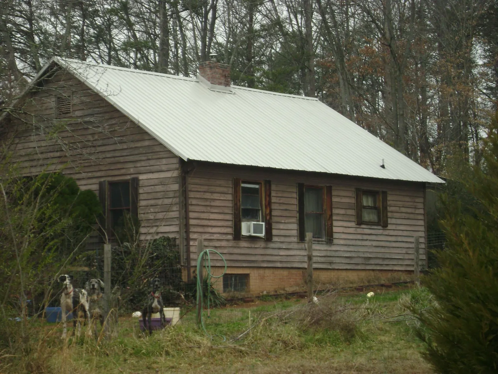 White metal roof on an old wood sided farmhouse, from a Metal Roof Installation job in Atlantic Highlands
